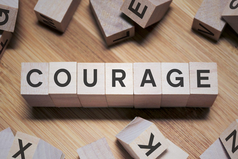 Courage word spelled out on scrabble tiles